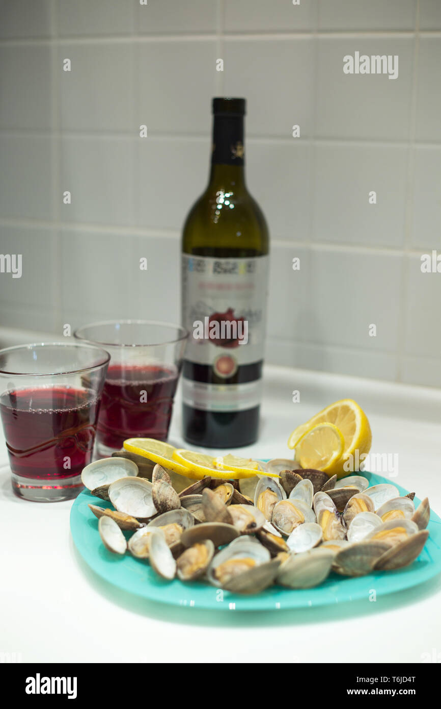 Lecker clam Spisula-muschel-auf Folie Kochen im Ofen gegrillte Neben Gläsern und einer Flasche roten Granatapfel Wein Stockfoto