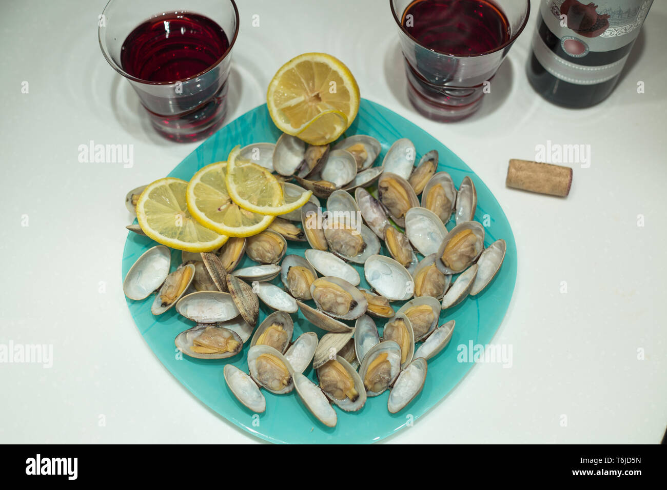 Lecker clam Spisula-muschel-auf Folie Kochen im Ofen gegrillte Neben Gläsern und einer Flasche roten Granatapfel Wein Stockfoto