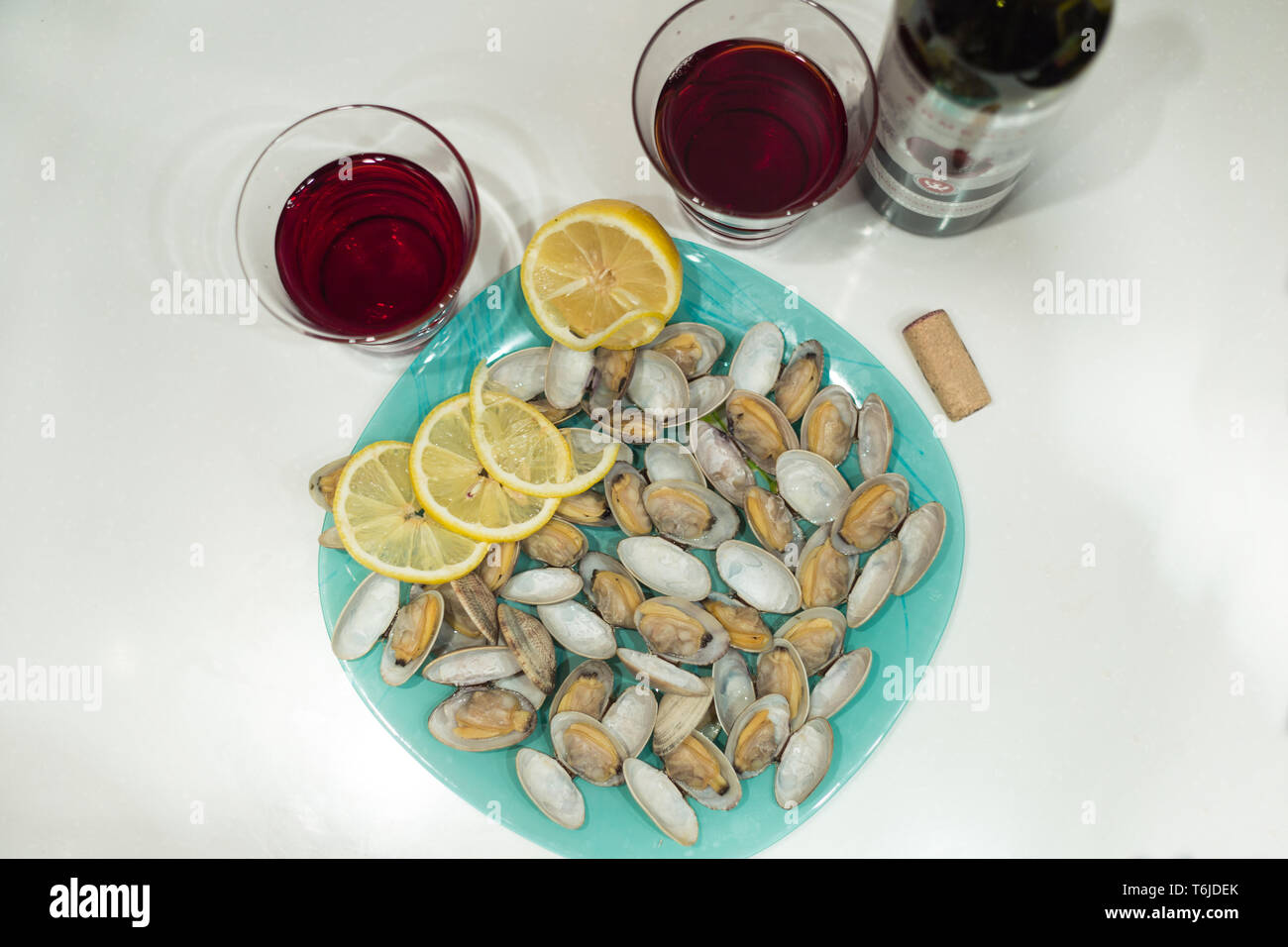 Lecker clam Spisula-muschel-auf Folie Kochen im Ofen gegrillte Neben Gläsern und einer Flasche roten Granatapfel Wein Stockfoto