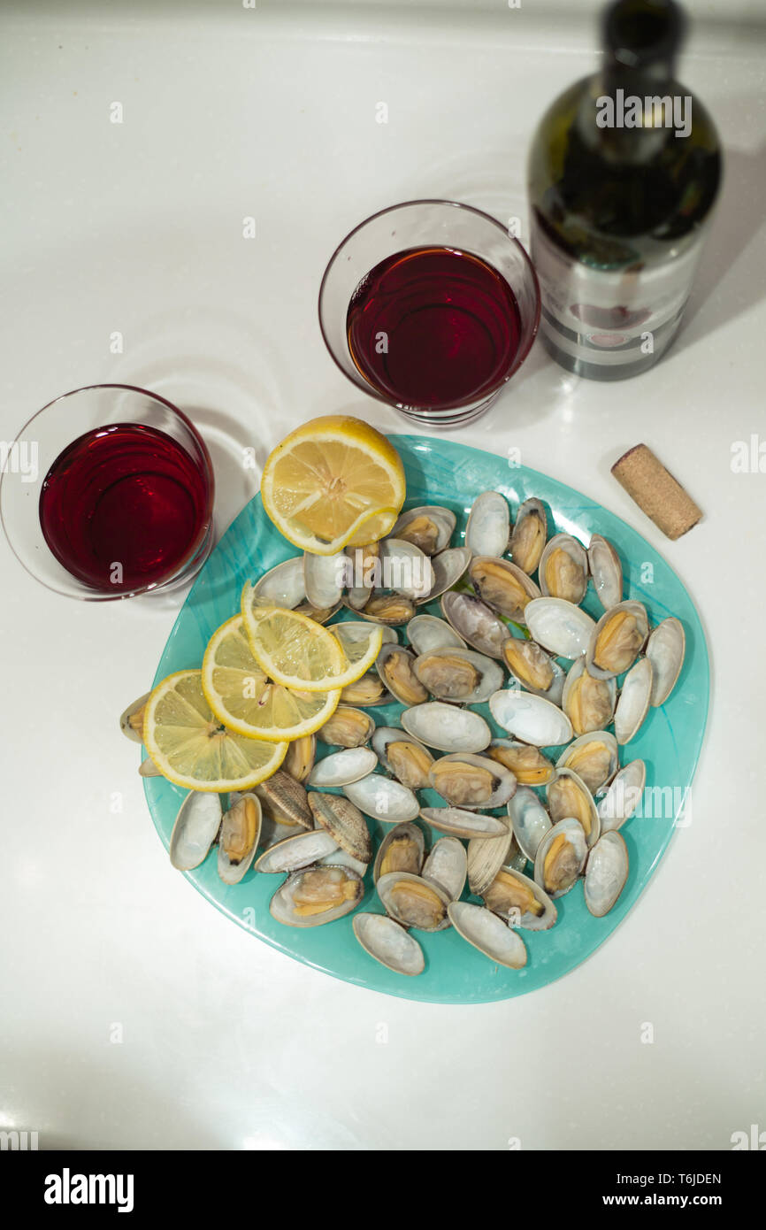 Lecker clam Spisula-muschel-auf der Folie, kochen Sie es im Ofen, auf dem Grill, in der Nähe der Gläser und eine Flasche roten Granatapfel Wein, Stockfoto