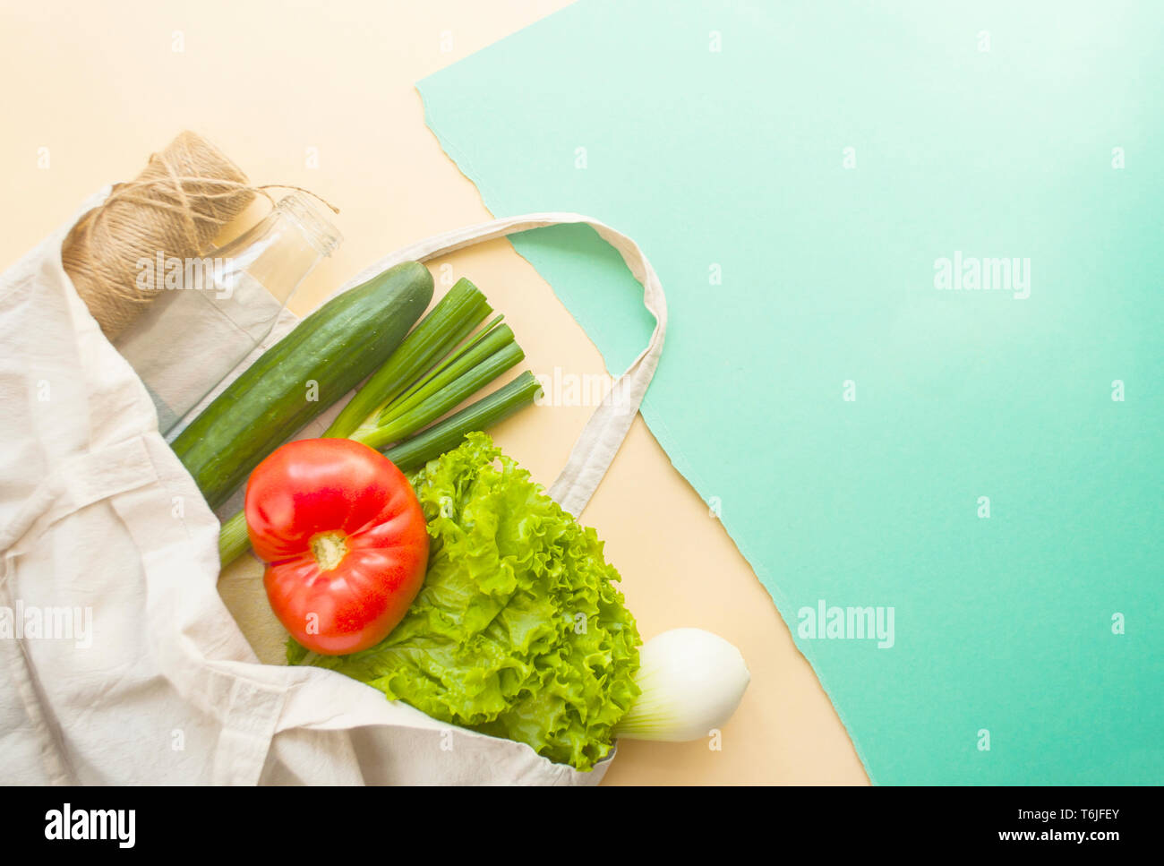 Frisches Obst und Gemüse im eco Beutel auf beige und türkis Farbe Hintergrund mit Copyspace. Kunststoff Konzept. Stockfoto