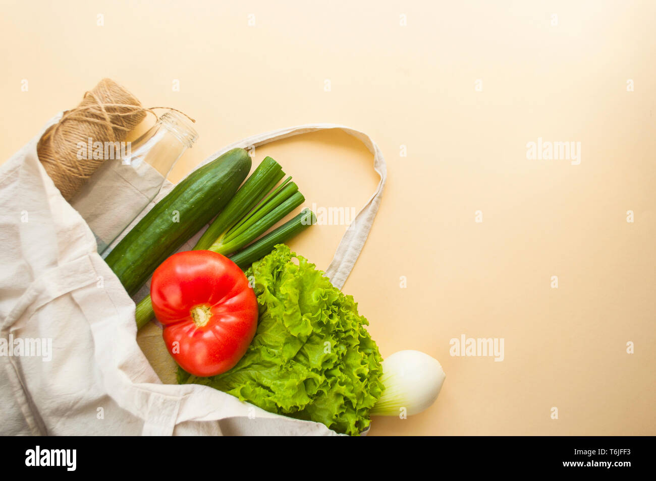 Frisches Obst und Gemüse im eco Beutel auf beige Farbe Hintergrund mit Copyspace. Kunststoffabfälle Konzept. Stockfoto