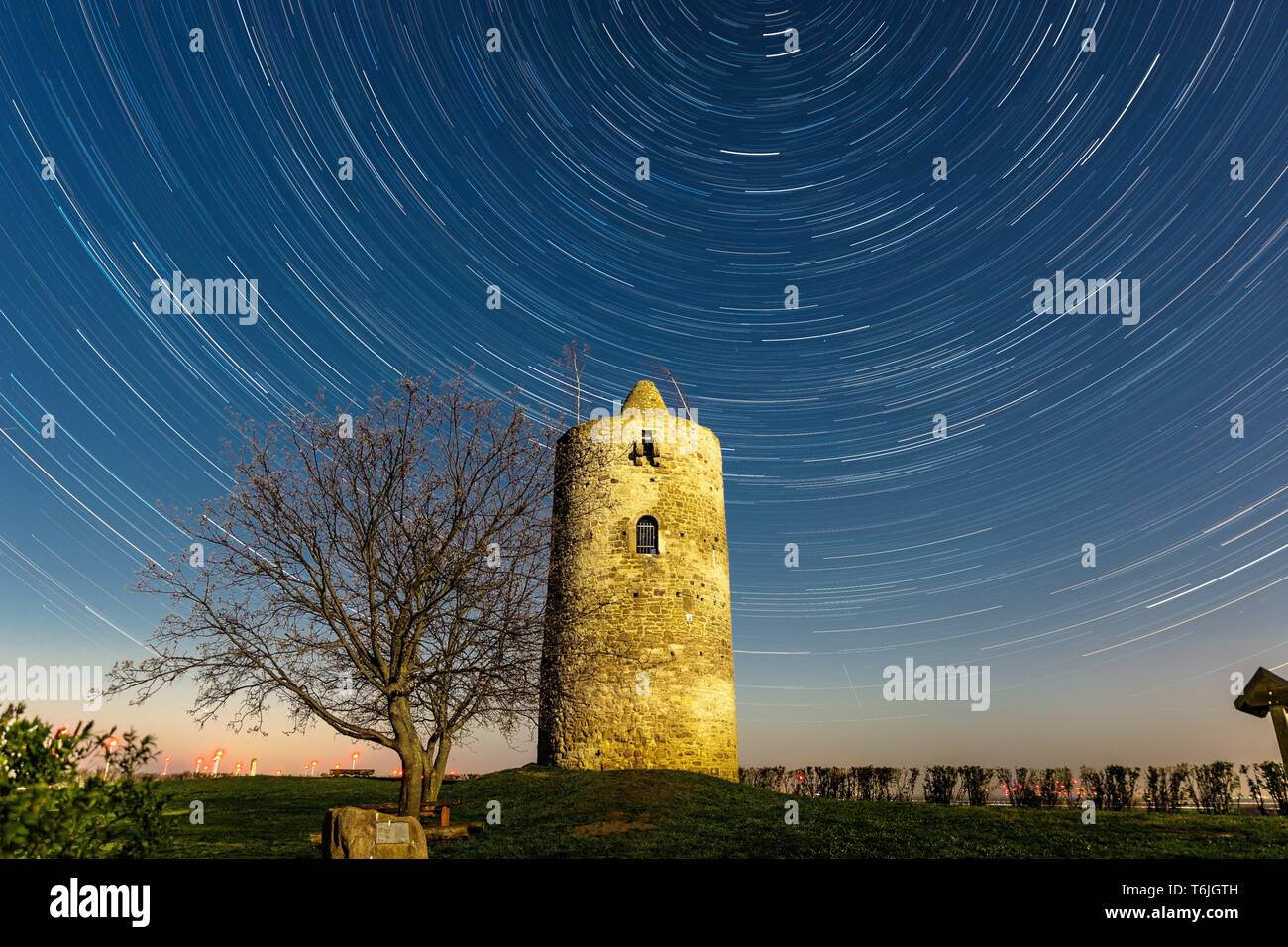 Alten Wachturm in der Nacht vom Vollmond beleuchtet, mit rotierenden Sky (Star Wanderwege) Stockfoto