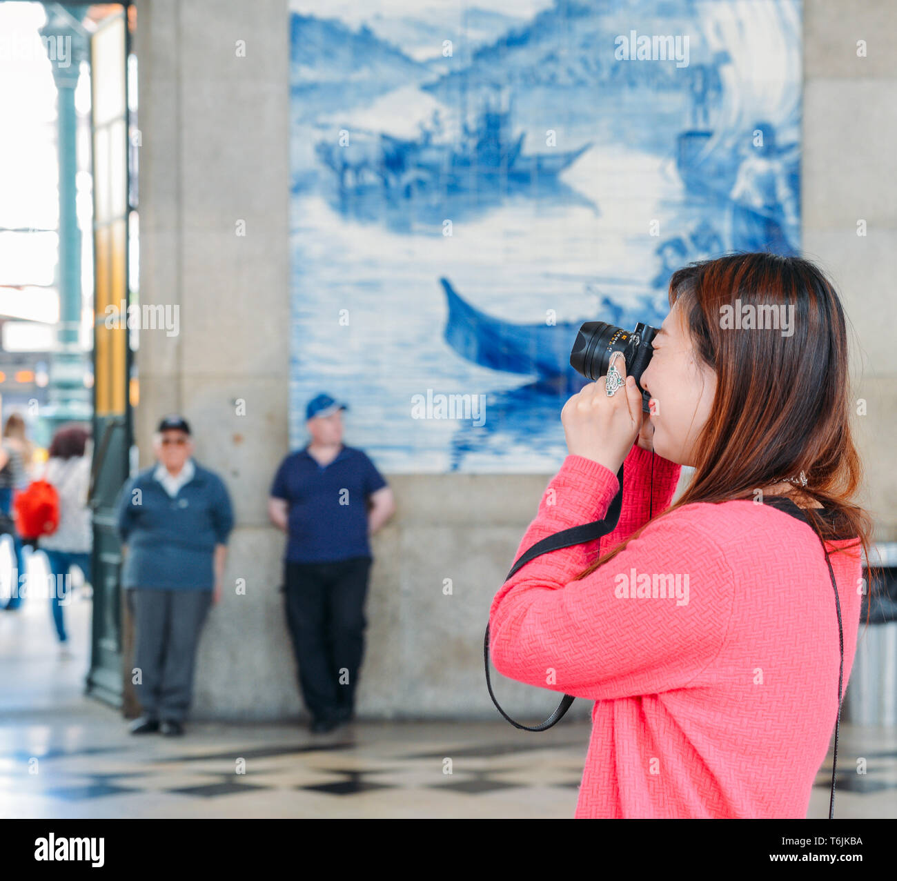 Porto, Portugal - April 29, 2019: Asiatische touristische Bilder im historischen Bahnhof Sao Bento in Porto, Portugal. Wand ist in b Stockfoto