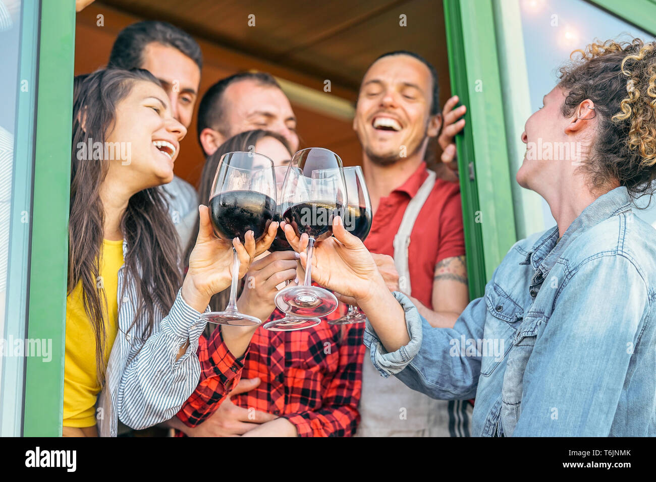 Gerne Freunde jubeln mit Gläser Rotwein auf der Terrasse - Junge Leute Spaß trinken, Toasten und gemeinsam lachen in einem Weinberg Haus Stockfoto