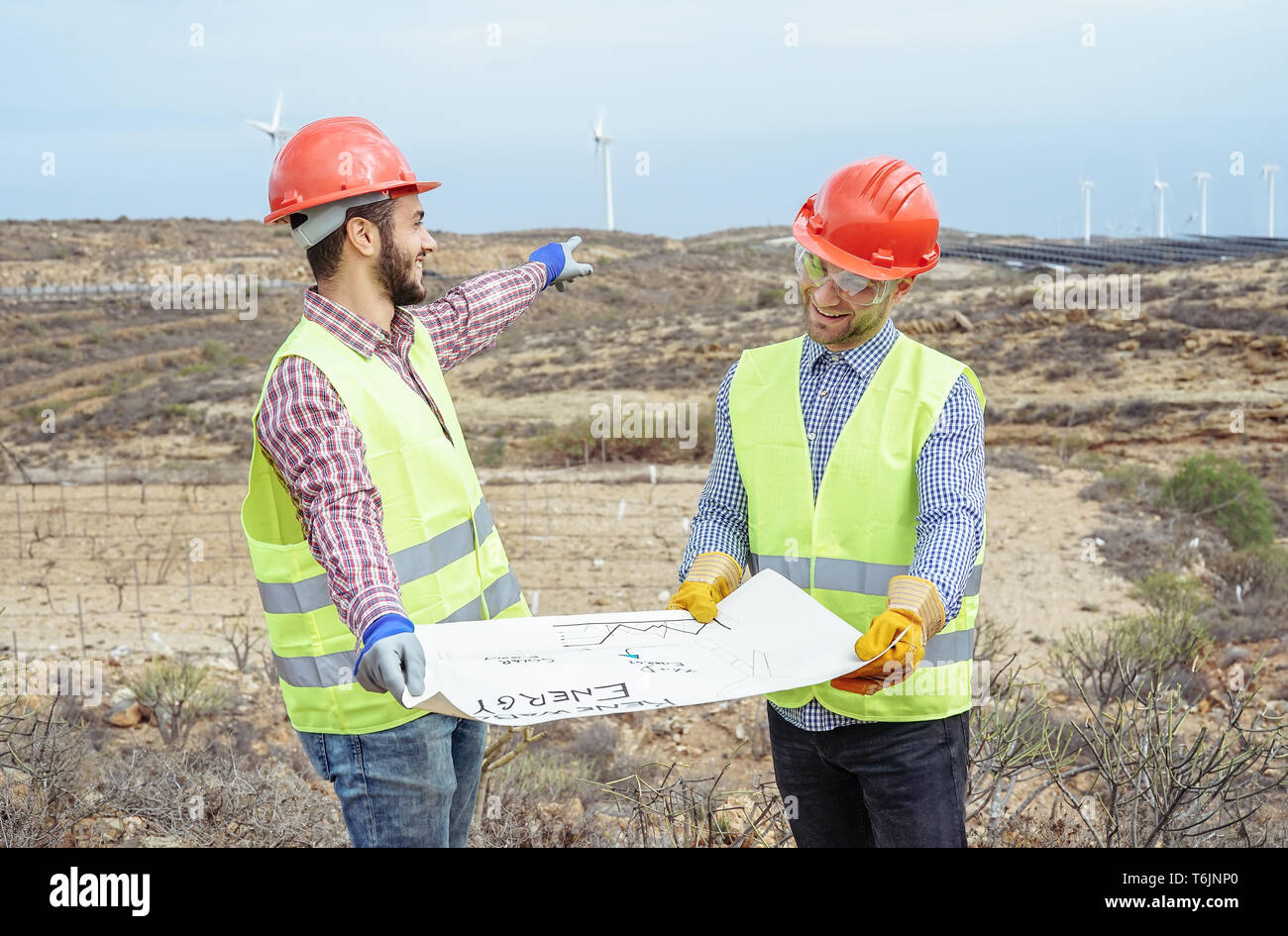 Arbeitnehmer Ingenieure Lesen und Reden über das neue Projekt für erneuerbare Energien - Bauherren diskutieren und zeigen, wie Mühle zu errichten und Panels Solar Stockfoto