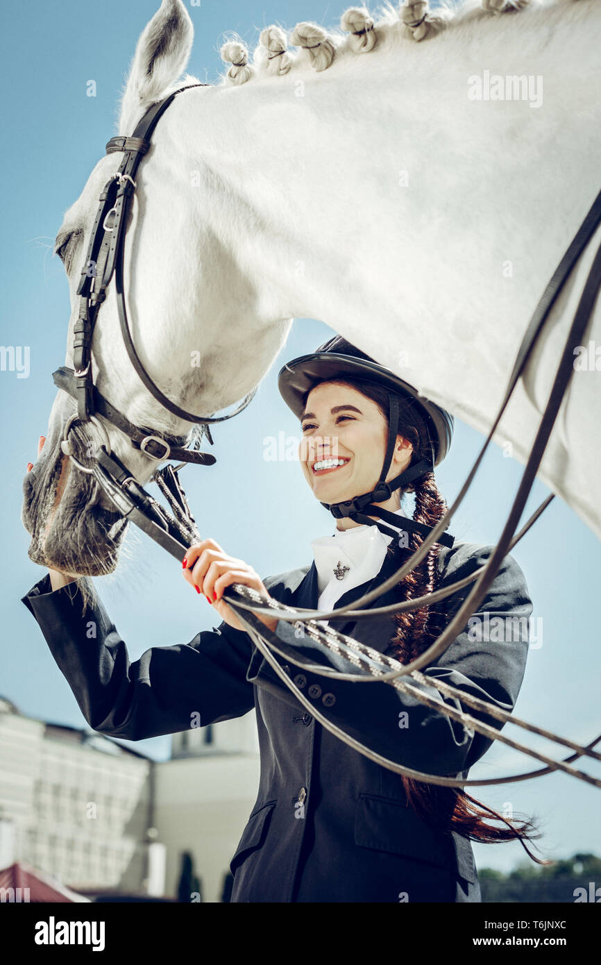 Low Angle eine schöne positive Frau mit ihrem Pferd Stockfoto
