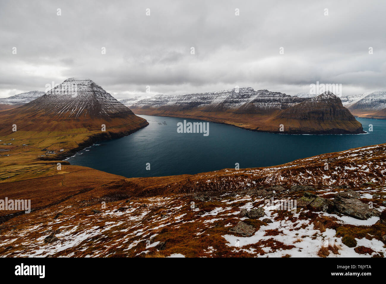 Panoramablick vom Kap Enniberg in das kleine Dorf Viðareiði, seine Fjorde, Kunoy Insel und schneebedeckte Berge (Färöer, Dänemark, Europa) Stockfoto