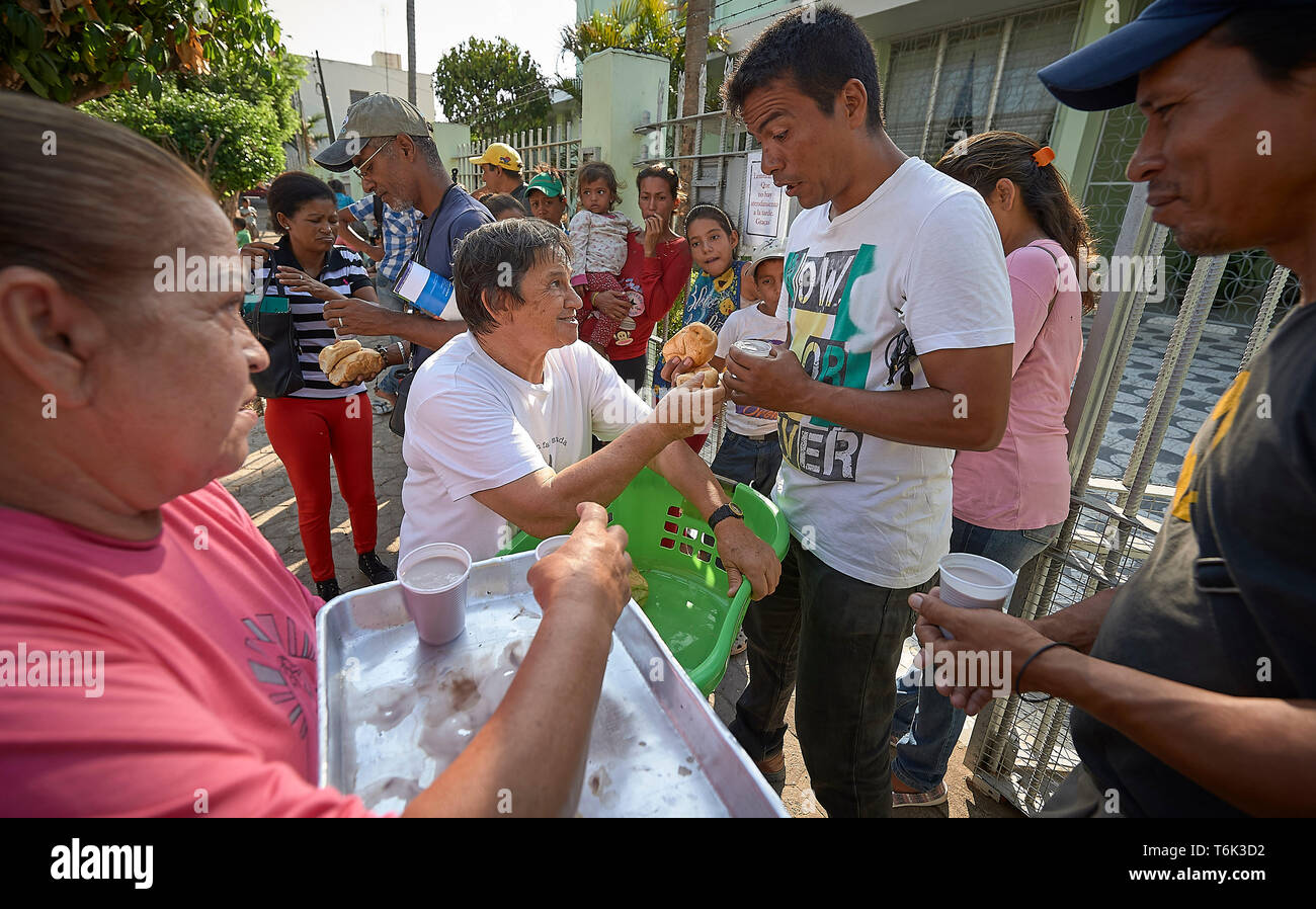 Venezolanische Flüchtlinge erhalten Essen auf der Straße in Boa Vista, Brasilien, als Teil einer Not-ernährungsprogramm von Consolata Schwestern geführt wird. Stockfoto