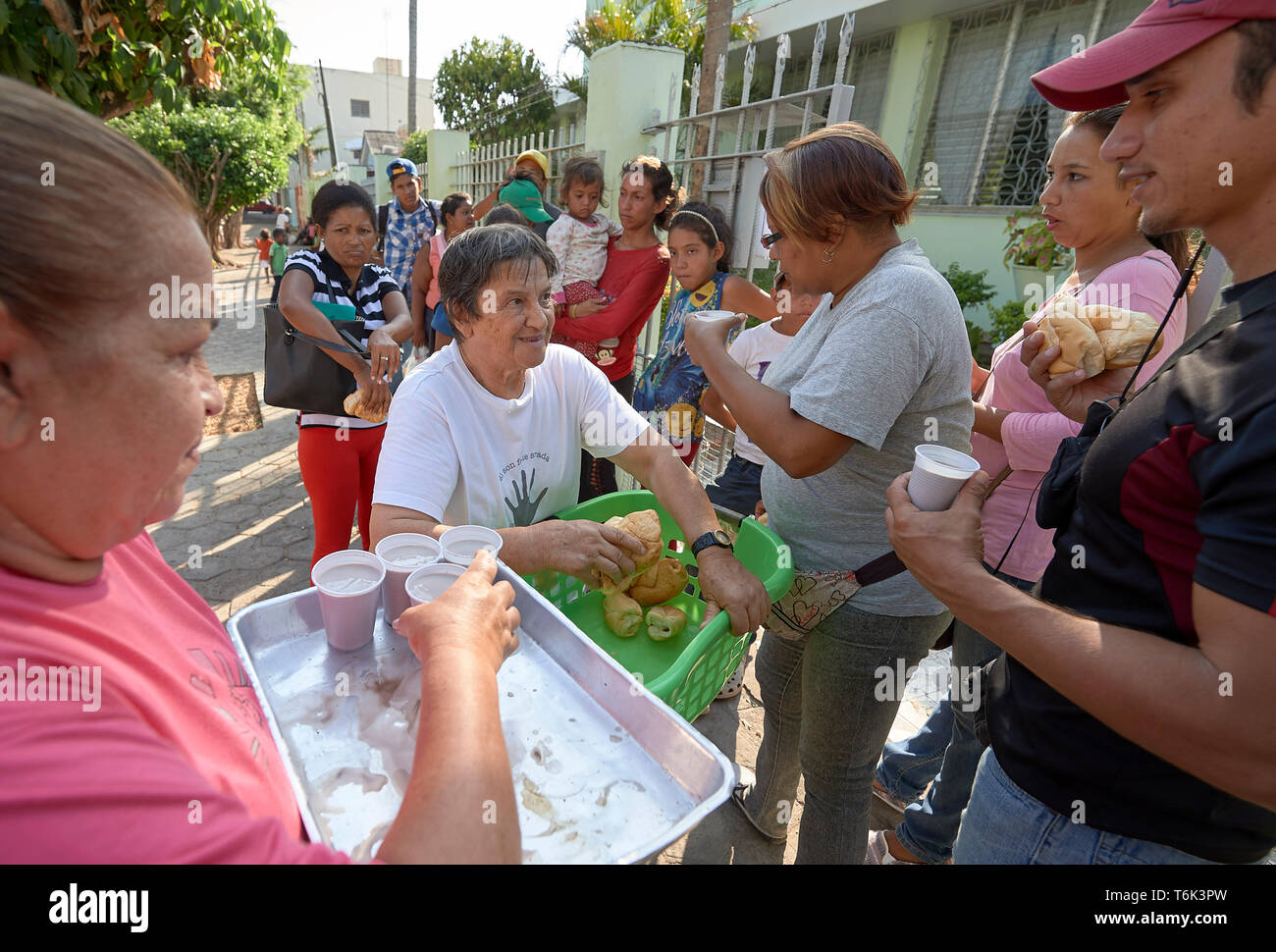 Venezolanische Flüchtlinge erhalten Essen auf der Straße in Boa Vista, Brasilien, als Teil einer Not-ernährungsprogramm von Consolata Schwestern geführt wird. Stockfoto