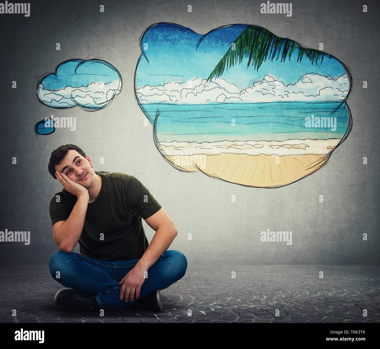 Junger Mann Träumer auf dem Boden sitzend die Hand unter die Wange lehnte sich auf einer Seite nach oben schauen, träumen von neuen Reiseziel als Gedanke bubble Clou Stockfoto