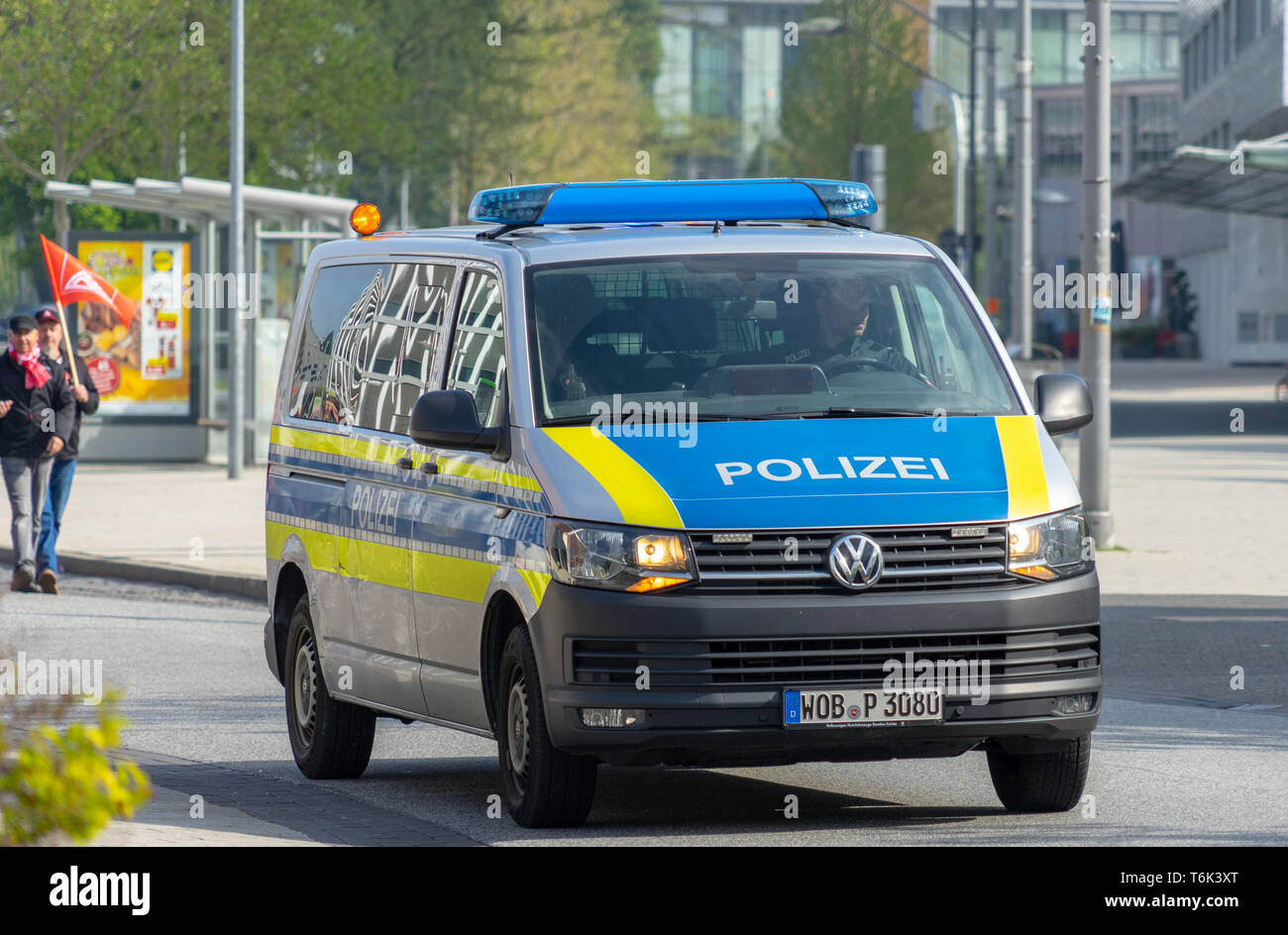 Wolfsburg, Deutschland, 1. Mai 2019: ein VW-Bus als Polizei Auto mit blauen und gelben Farbe und blaues Licht auf dem Dach Laufwerke vor dem 1. Mai demonstrat Stockfoto