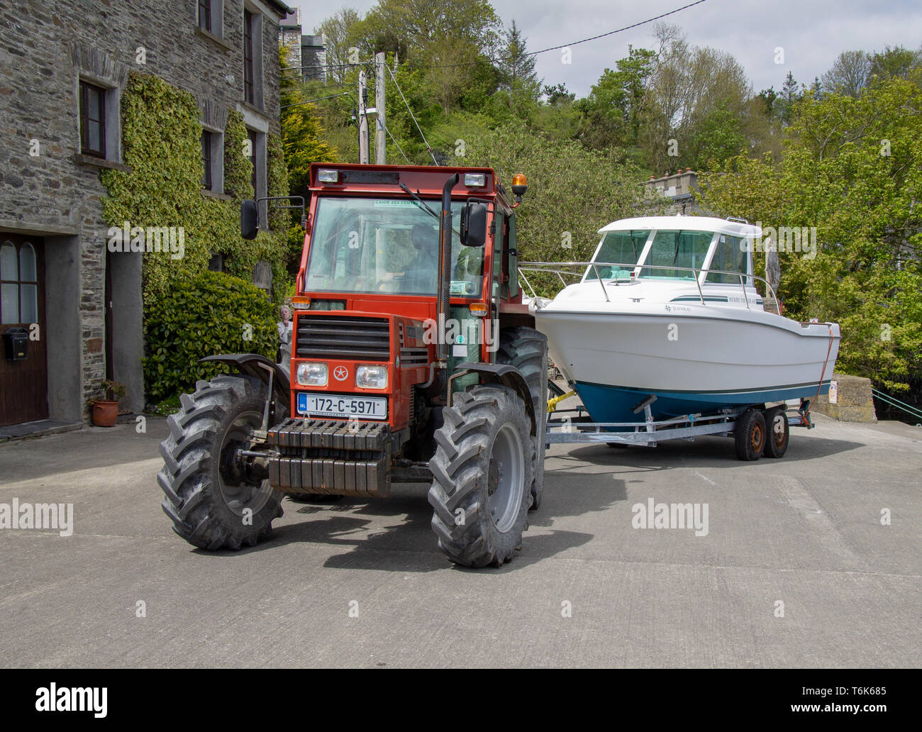 Traktor eine Cabin Cruiser Motorboot auf einem Anhänger wieder auf einer Helling Stockfoto