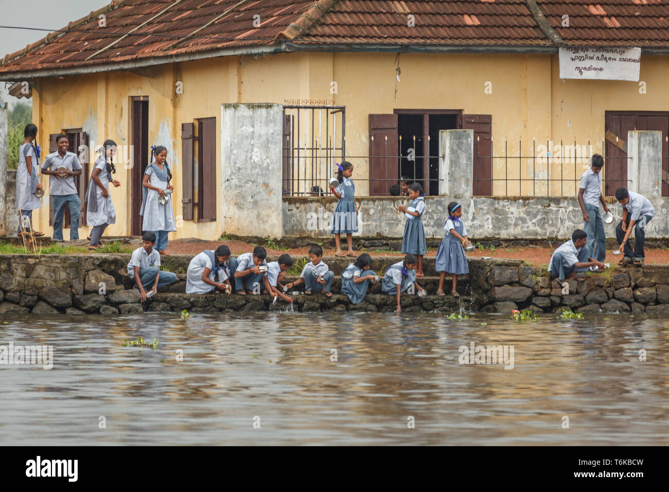 Schule Kinder in Uniformen nach River's Edge kommen in der Schule ihr Geschirr zu Waschen nach dem Mittagessen Stockfoto