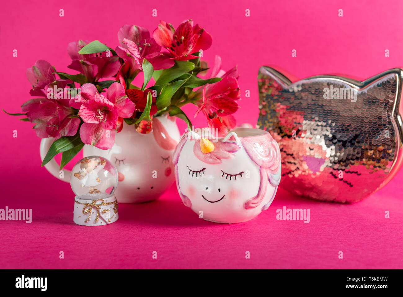 Einhorn Becher mit alstroemeria Blumen und Kitty Bank Stockfoto