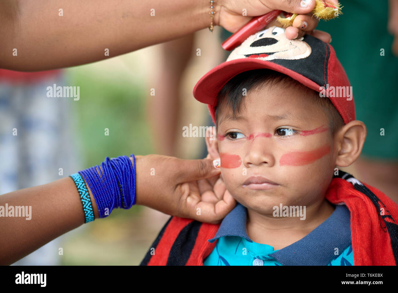 3-jährige Simon Tamakorih Kanamari erhält sein Gesicht malen mit urucum, bevor ein Protest der indigenen Bevölkerung durch Atalaia do Norte in Brasilien. Stockfoto