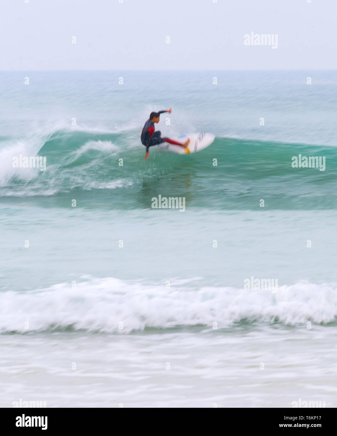 Die jungen Surfer in Neoprenanzug auf einer Welle in motion blur, Peniche, Portugal Stockfoto