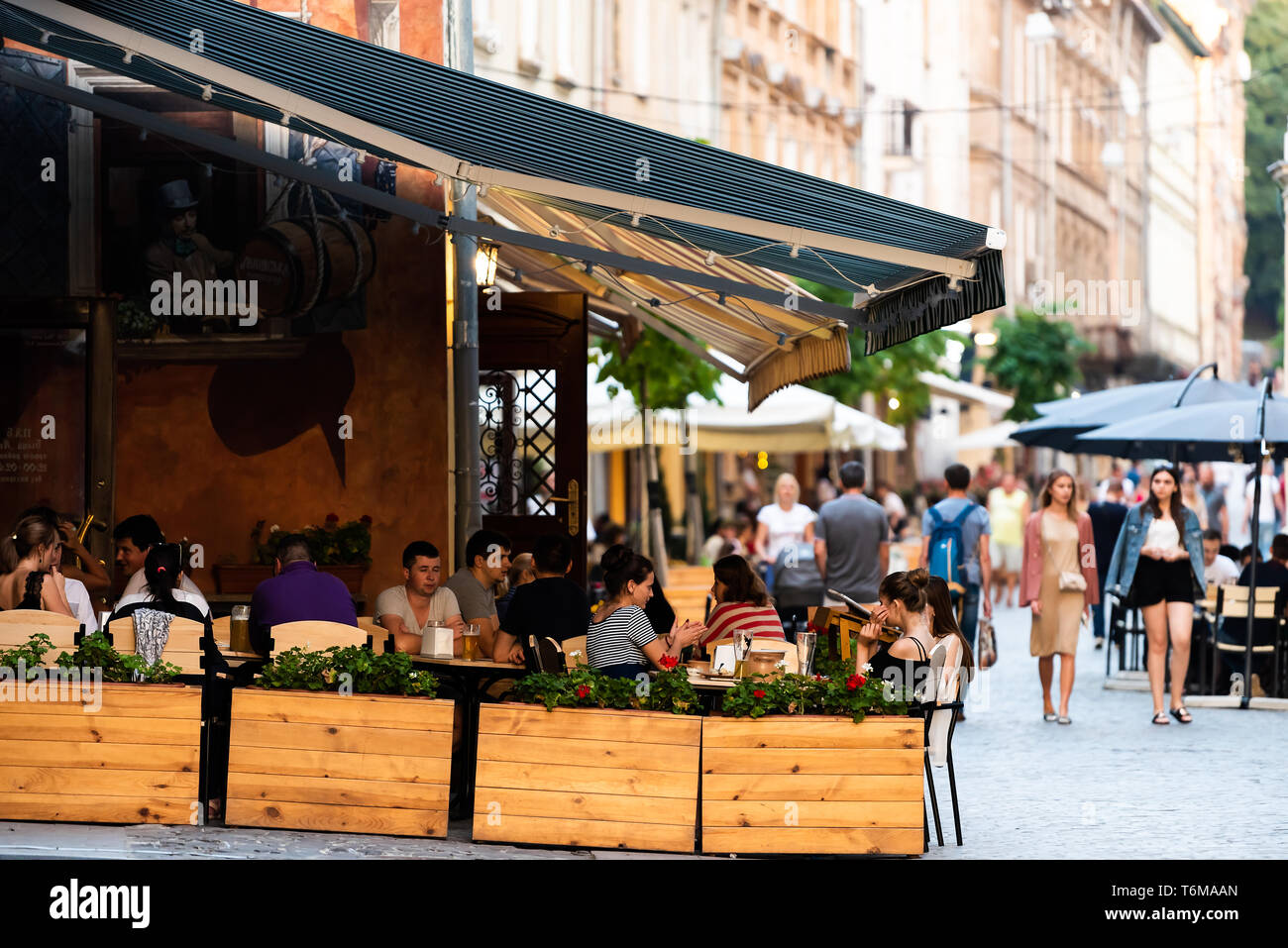 Lemberg, Ukraine - Juli 30, 2018: Straße in der Ukrainischen polnischen Lvov Stadt bei Tag mit historischen Gebäuden in der Altstadt und Cafe Tische Stühle im Restauran Stockfoto