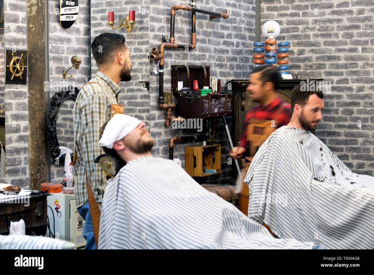 Blick in das Innere des Friseursalons, Männer, die auf Barbersesseln sitzen Portugiesischer Friseursalon trimmt Kunden Bärte in Lissabon Portugal EU KATHY DEWITT Stockfoto