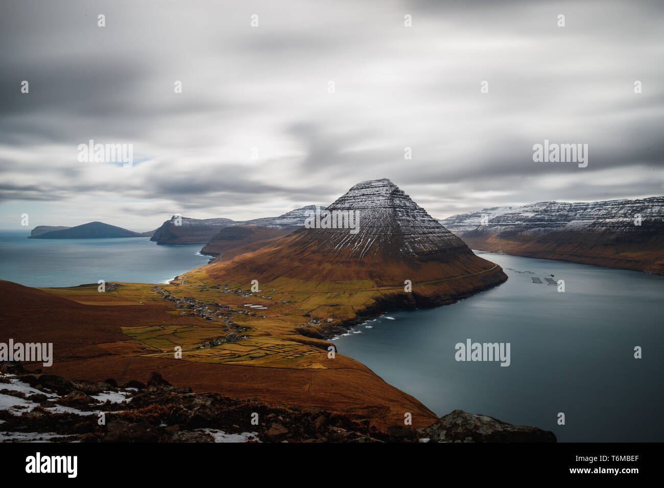Lange Belichtung Panoramablick vom Kap Enniberg in Richtung des Dorfes Viðareiði, seine Fjord mit schneebedeckten Bergen (Färöer, Dänemark, Europa) Stockfoto
