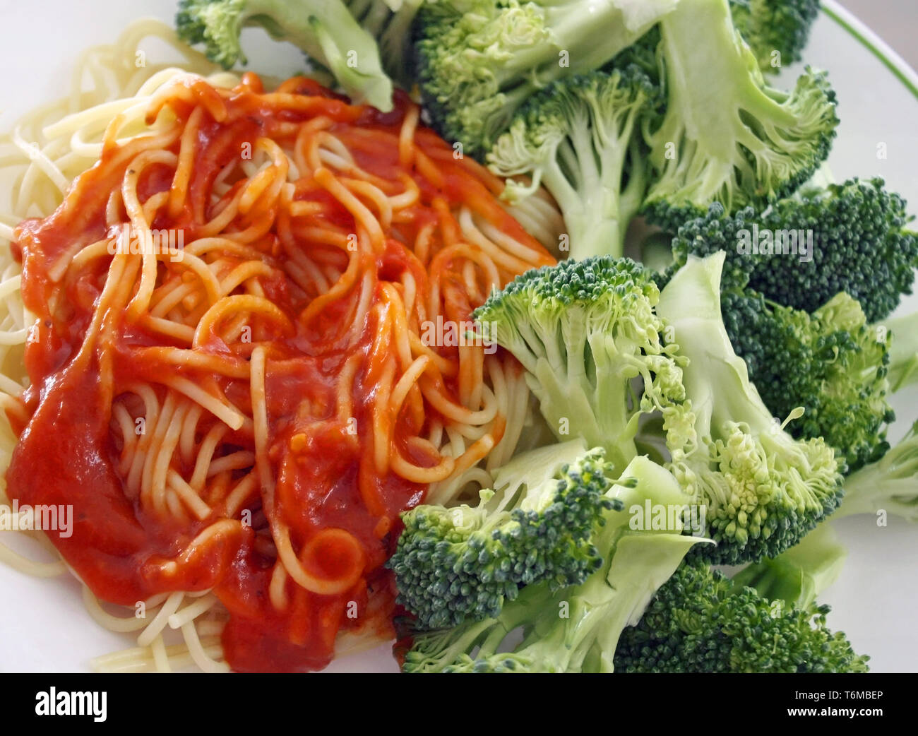Spaghetti Pasta mit einem hausgemachten fleischlosen Tomatensauce. Frische organische Brokkoli auf der Seite Stockfoto