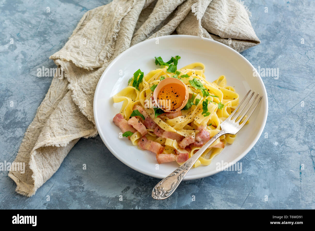 Pasta Carbonara mit Eigelb in eine weiße Platte. Stockfoto