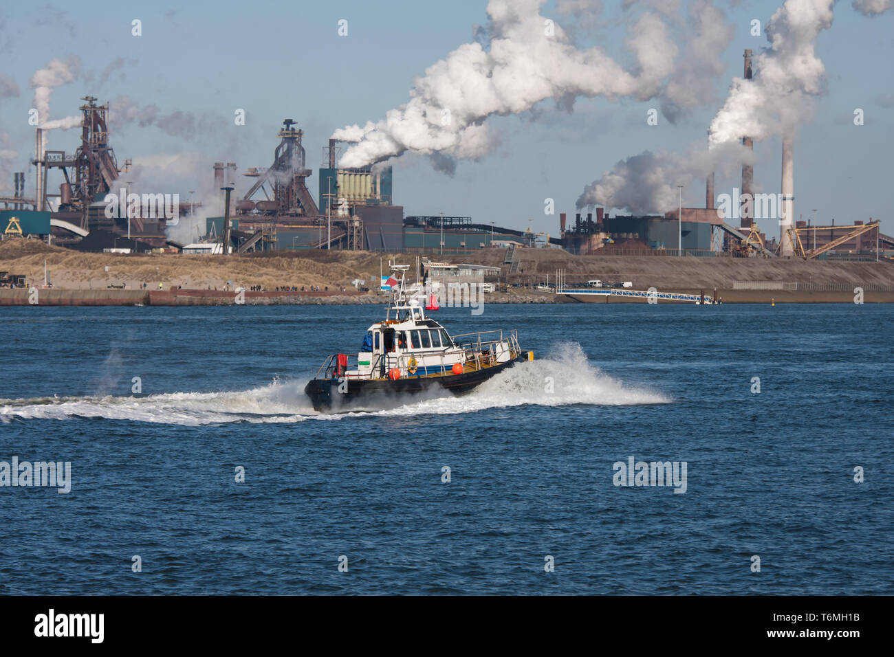 Niederländischen Stahlwerk entlang der Küste mit dem Motorboot Stockfoto