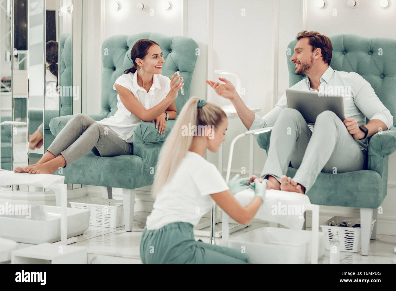 Freundliche gutaussehende Paar aktiv Sprechen während der Sitzung in Sessel Stockfoto