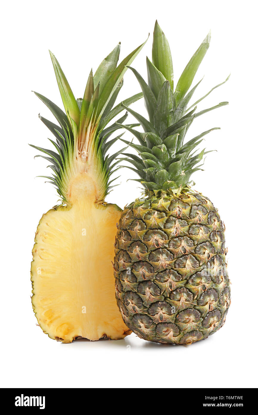 Die Hälfte der Reife Ananas und ganze Früchte auf weißem Hintergrund Stockfoto