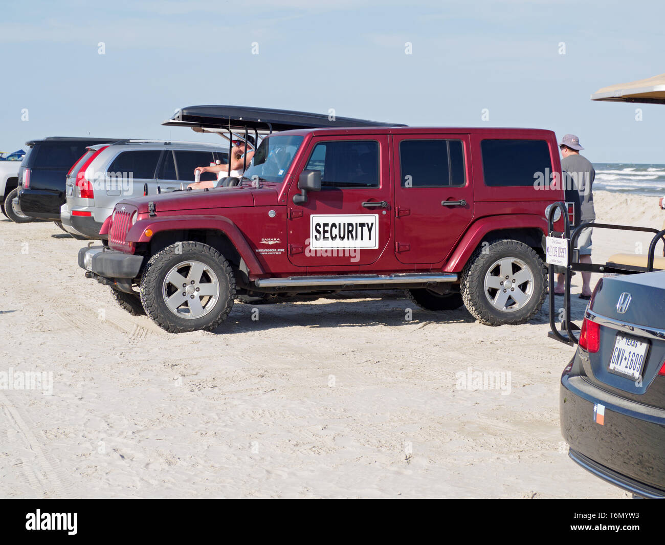 Ein roter Jeep Wrangler Unlimited Sahara mit einem Schild an der Tür in einem Strand Parkplatz geparkt während der 2019 Texas Sandfest. Texas USA. Stockfoto