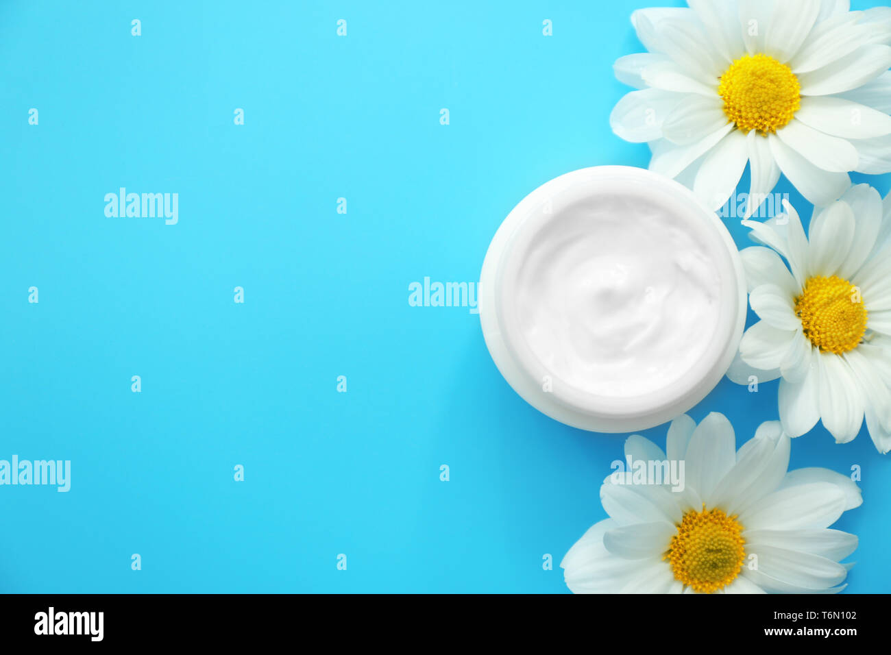 Jar-Creme mit pflanzlichen Extrakt und Blumen auf farbigen Hintergrund Stockfoto