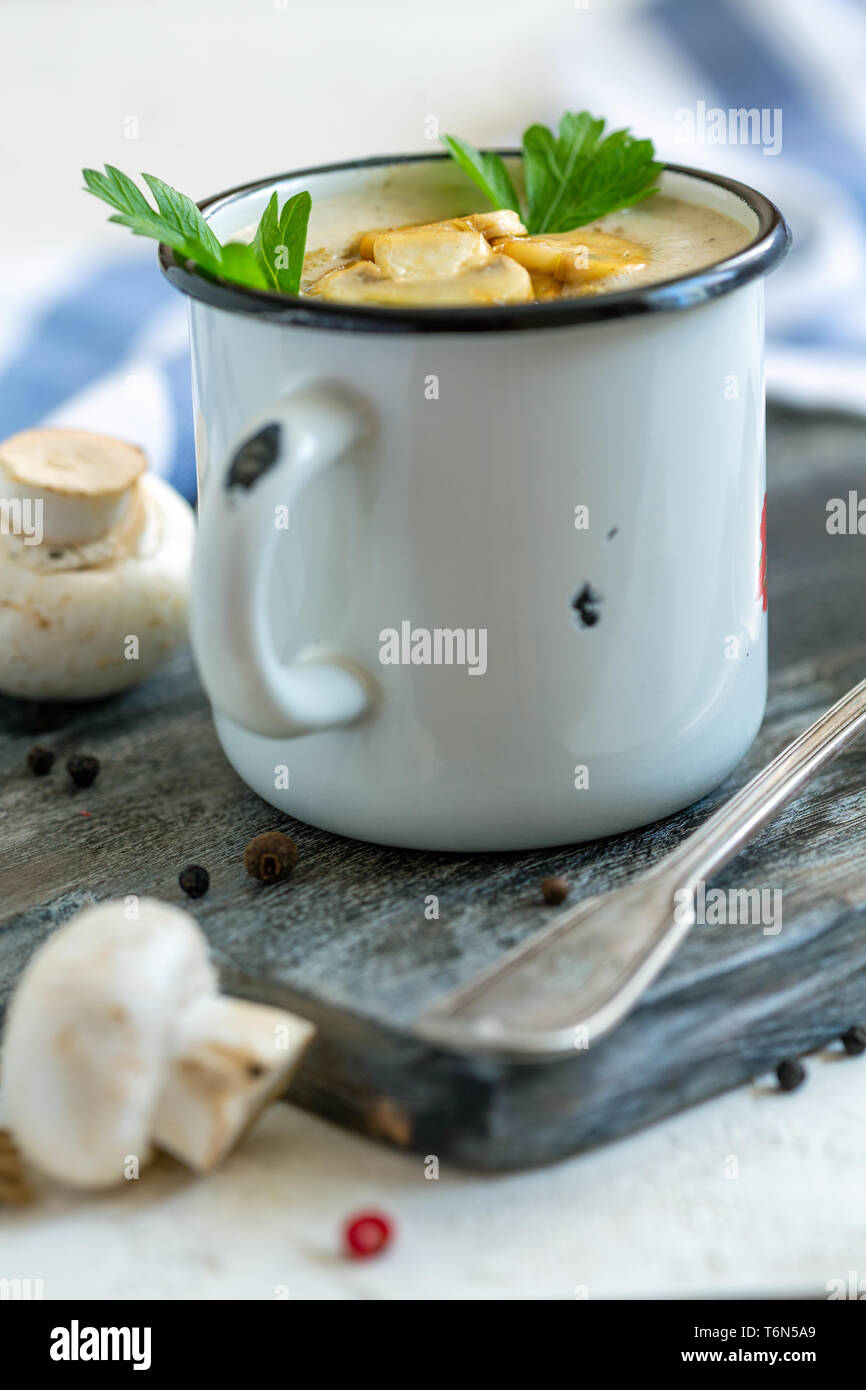 Creme - Suppe mit Champignons in einem Emaille Tasse. Stockfoto