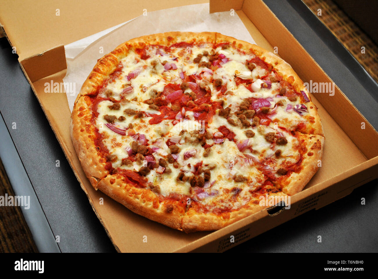 Fleisch Pizza mit Zwiebeln in einem Takeout Box Stockfoto