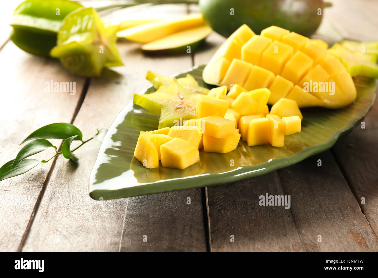 Mit Stücken von frischen Mangos und sternfrucht auf hölzernen Tischplatte Stockfoto