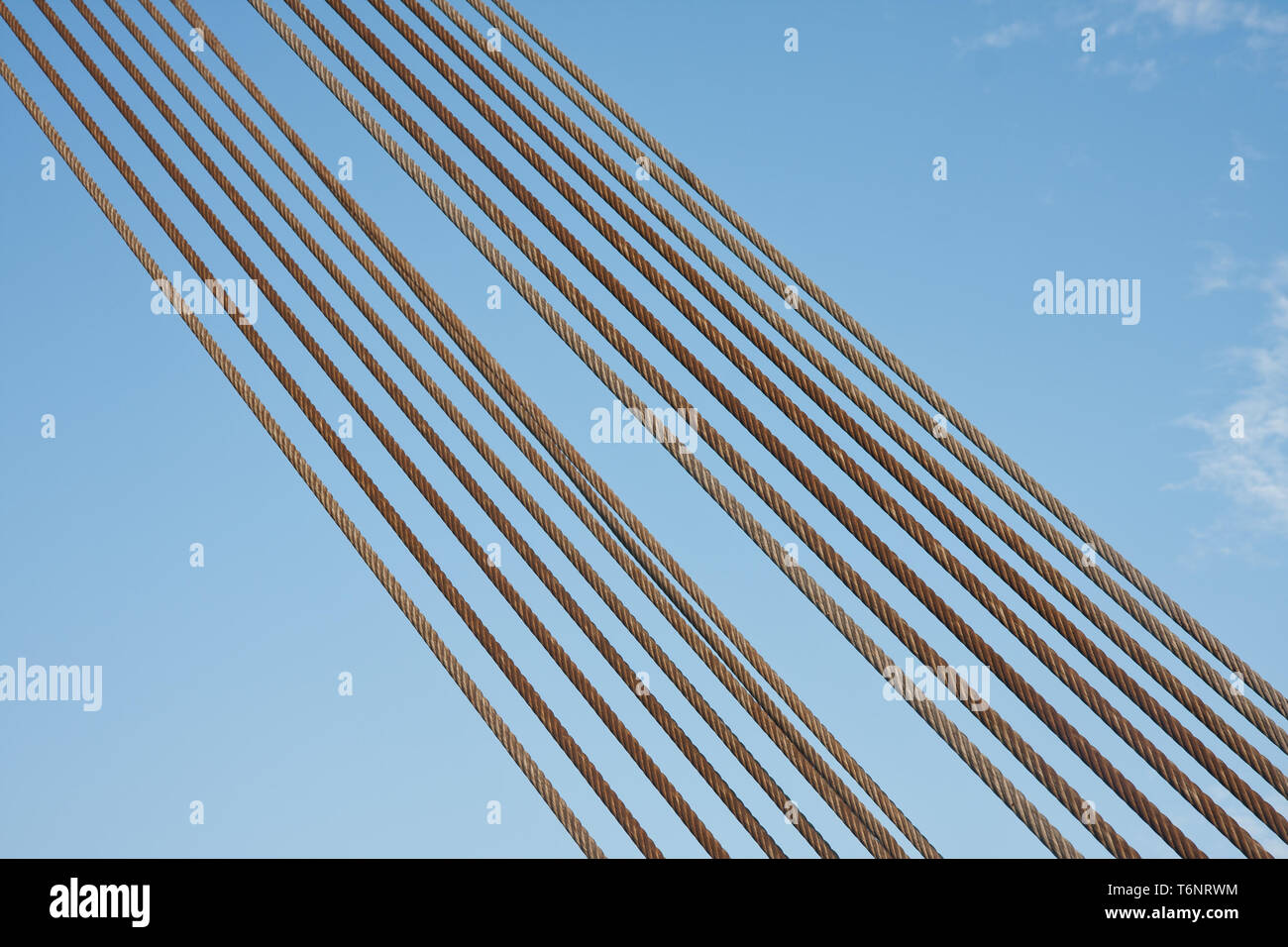 Satz von Stahlseilen vor blauem Himmel Stockfoto