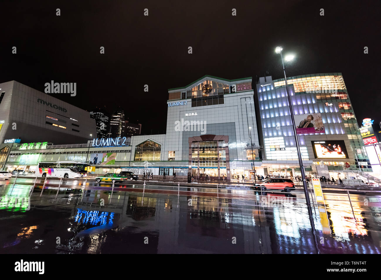 Shinjuku, Japan - 1. April 2019: Großes Einkaufszentrum in der Innenstadt von außen Stadt mit Neon Lichter Anzeichen nachts bei Regen mit Reflexion der Stockfoto