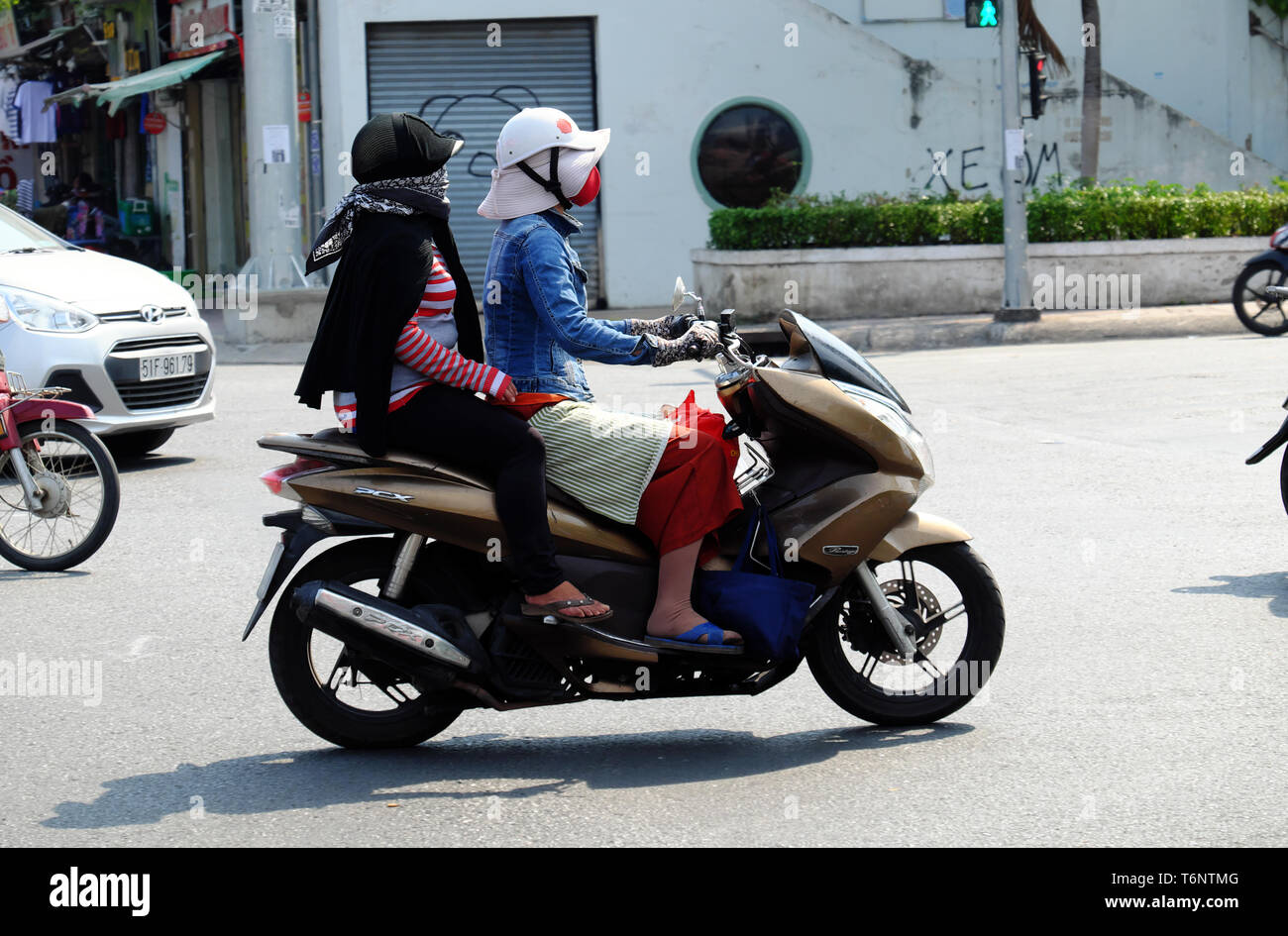 Vietnamesin Eine Schutzbrille, Gesichtsschutz, Mantel, Handschuhe,  Sonnenschutz, Fahrt Motorrad unter hoher Temperatur in heißen Tag, extreme  Wetterbedingungen, Vietnam Stockfotografie - Alamy