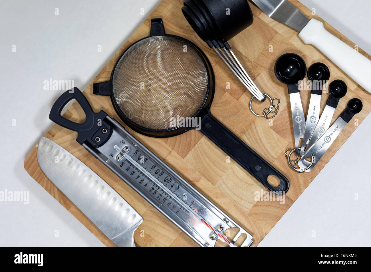 Flach Kochen/Backen wichtige Utensilien mit Holz Hackklotz, Edelstahl + black & white Theme. Sauber, modern und minimalistisch Stockfoto