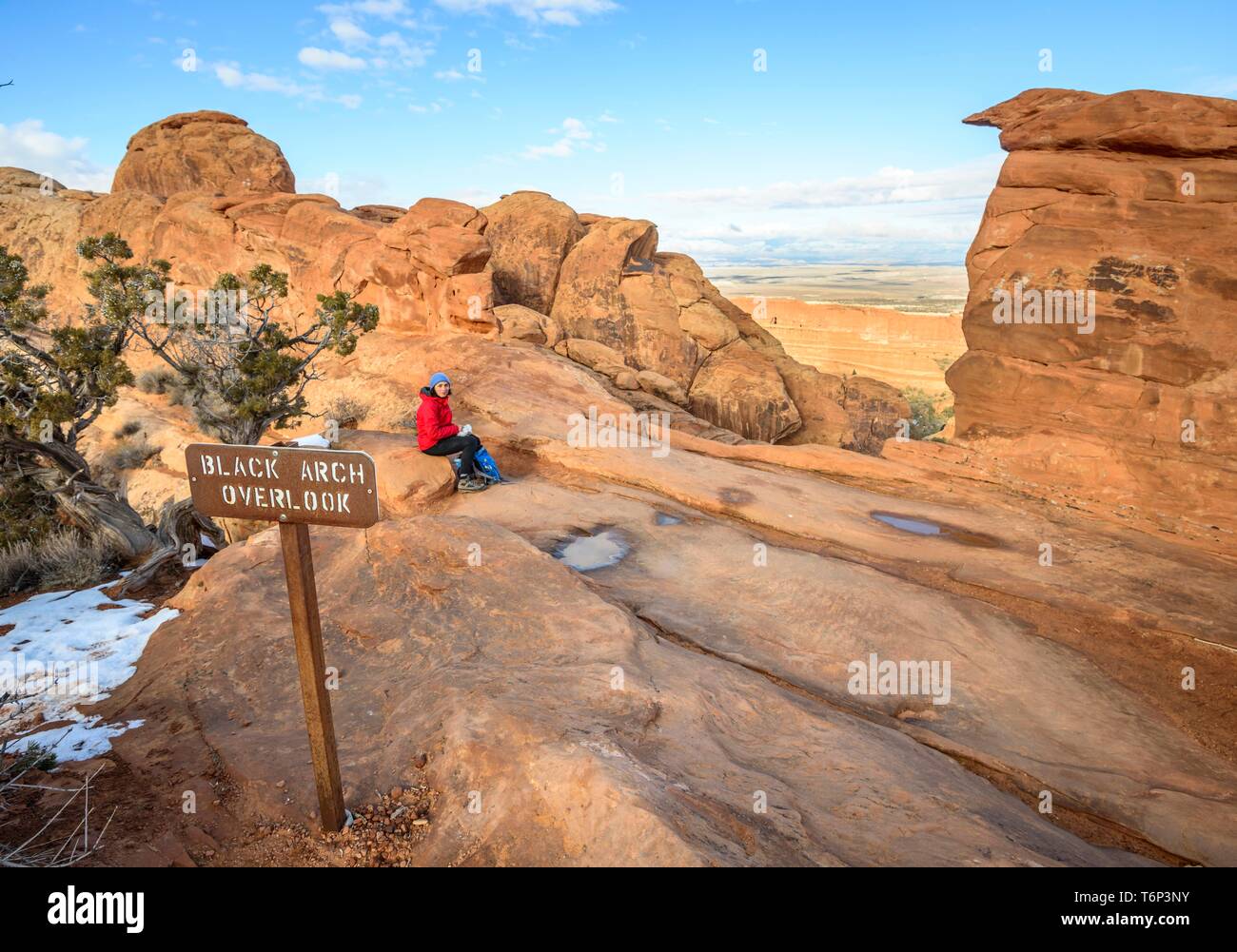 Touristische, junge Frau am Schwarzen Arch übersehen, Aussichtspunkt, Sandsteinfelsen, Devil's Garden Trail, Arches National Park, Utah, USA ruhen Stockfoto
