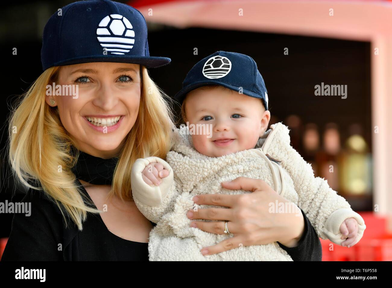 Mutter und Baby, 5 Monate, mit der gleichen Caps, Lachen, Baden-Württemberg, Deutschland Stockfoto