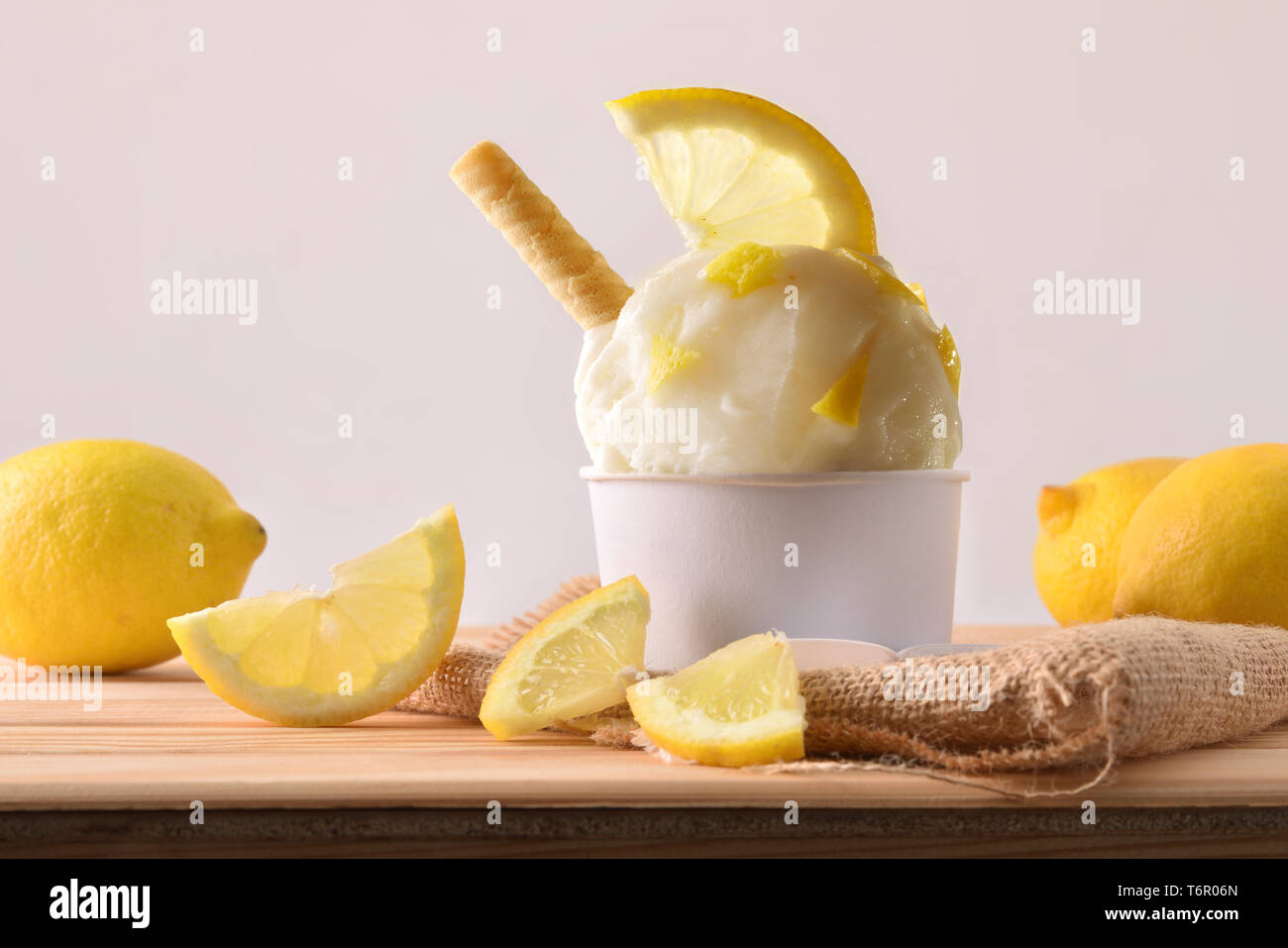 Eisbecher mit Zitrone Segmente auf einem hölzernen Tisch eingerichtet. Horizontale Komposition. Vorderansicht. Stockfoto