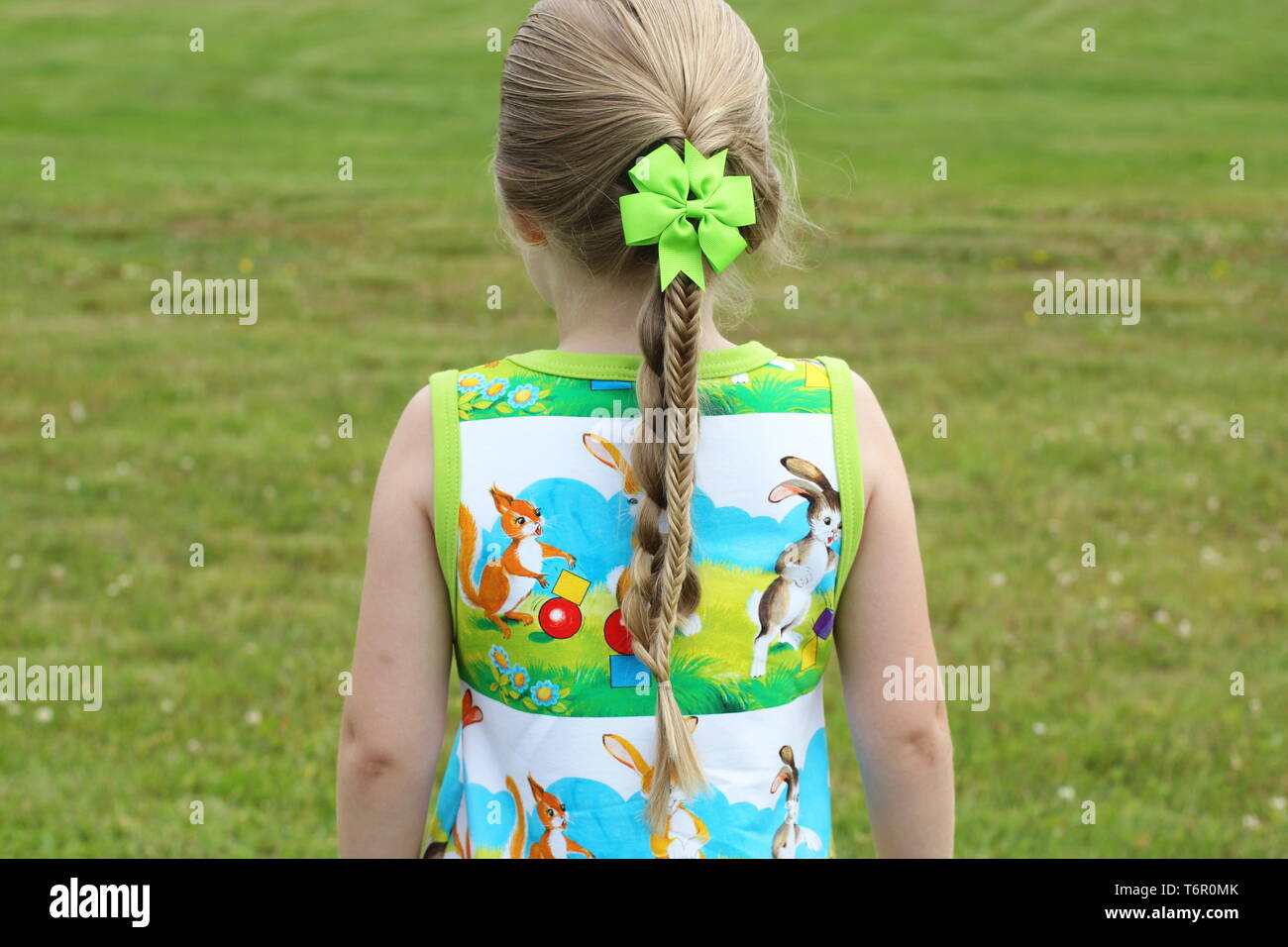 Ein Mädchen mit einem geflochtenen Frisur und ein grüner Bogen. Stockfoto