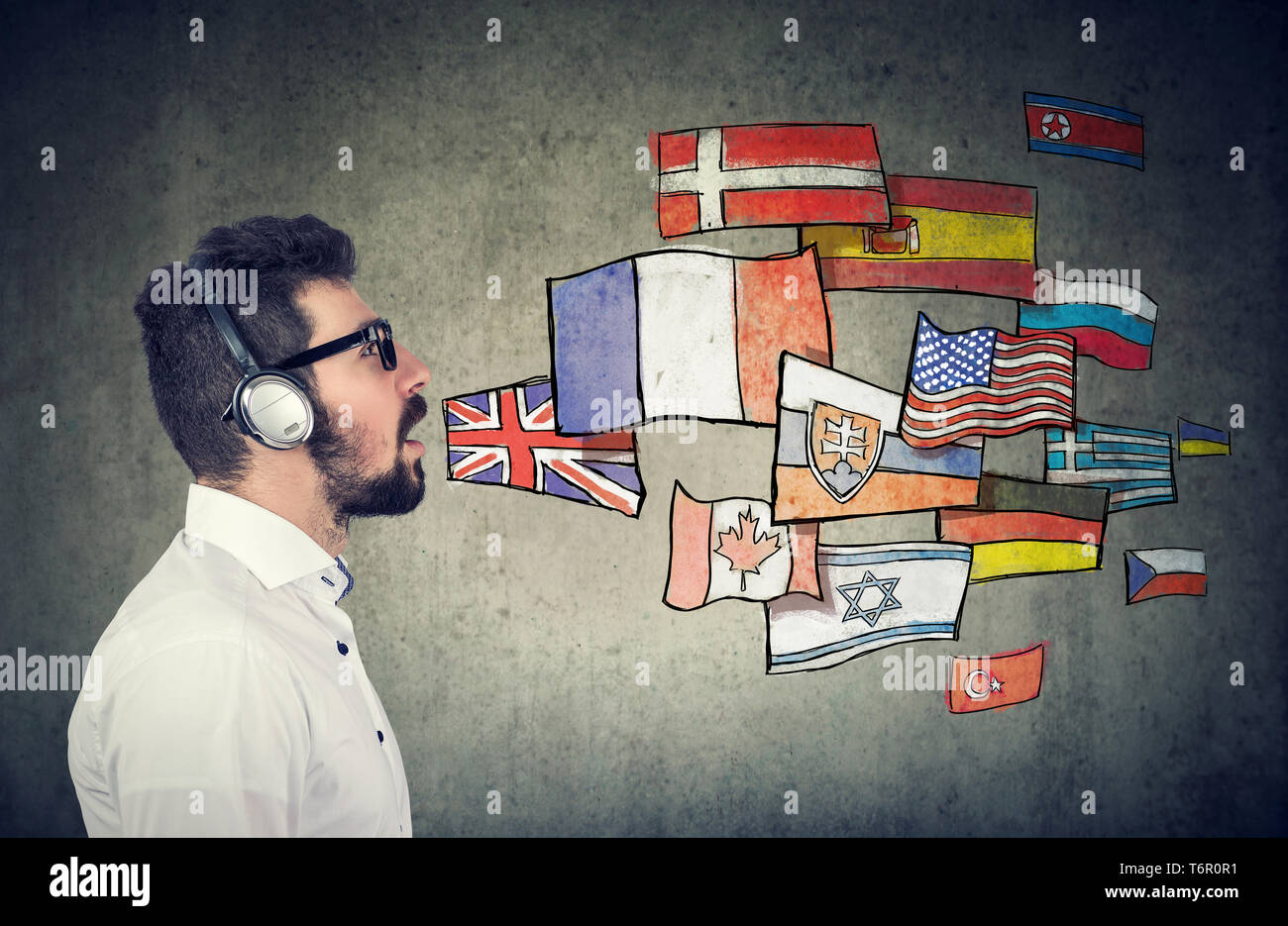 Junger Mann in Kopfhörer lernen verschiedene Sprachen Stockfoto