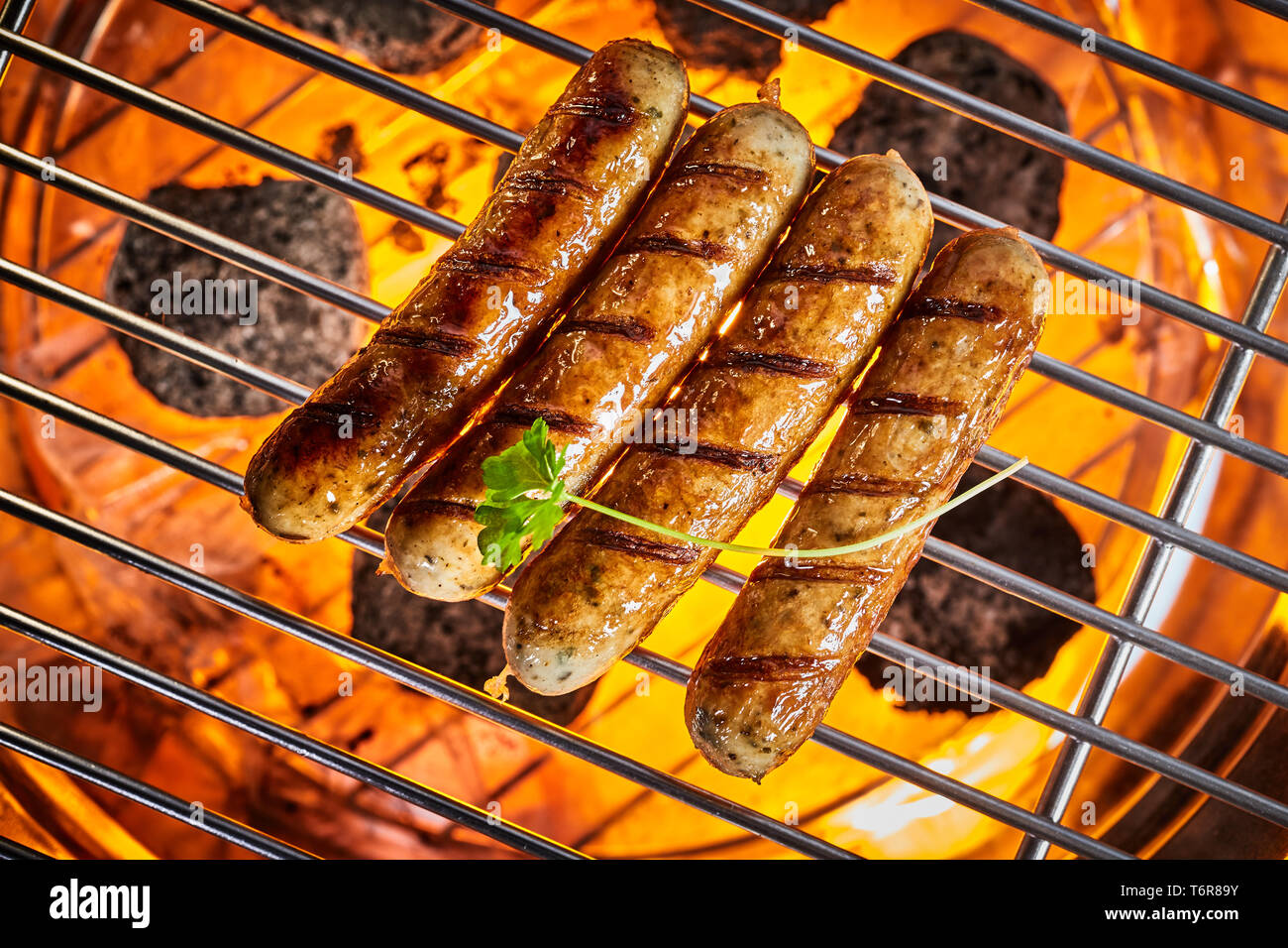 Gegrillte Würstchen am heißen Grill von oben mit einem Blatt frische  Petersilie. Full Frame close-up Overhead shot Stockfotografie - Alamy