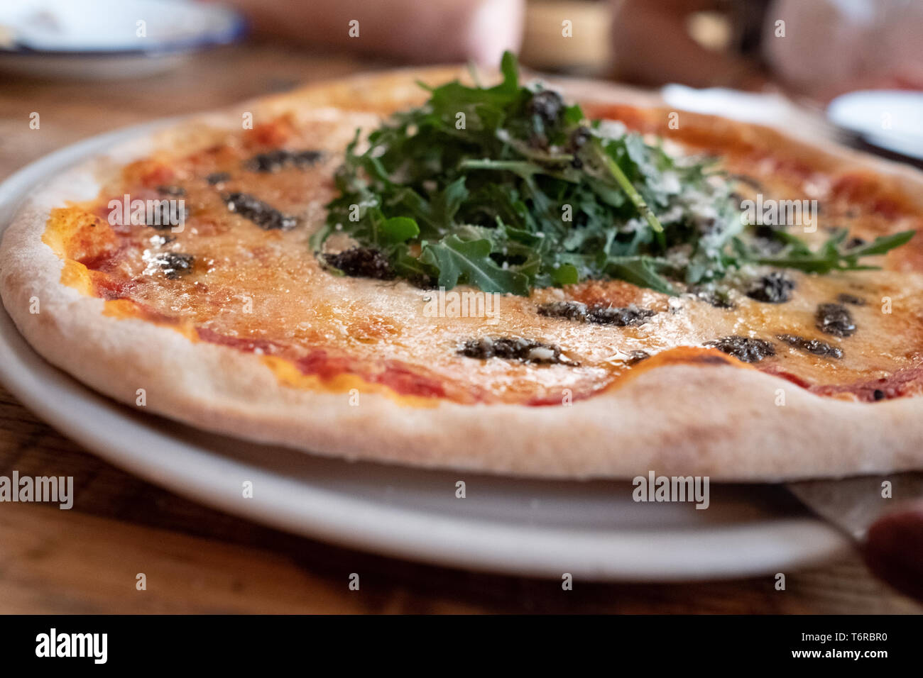 Stein Pizza mit provolone Käse, tartufata und Rucola Stockfoto