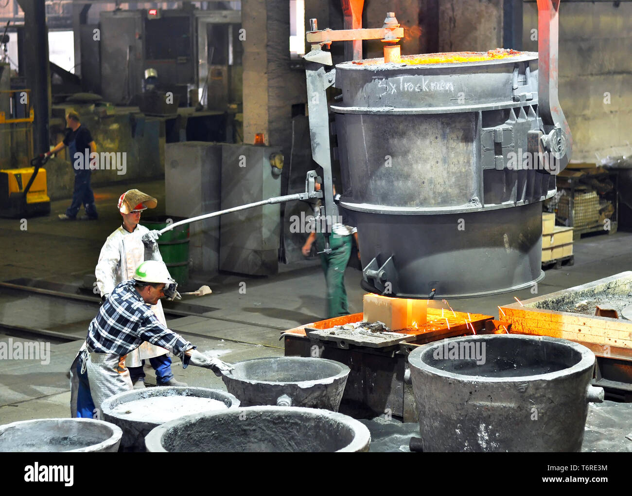 Produktion von Metallkomponenten in einer Gießerei - Gruppe der Arbeitnehmer Stockfoto