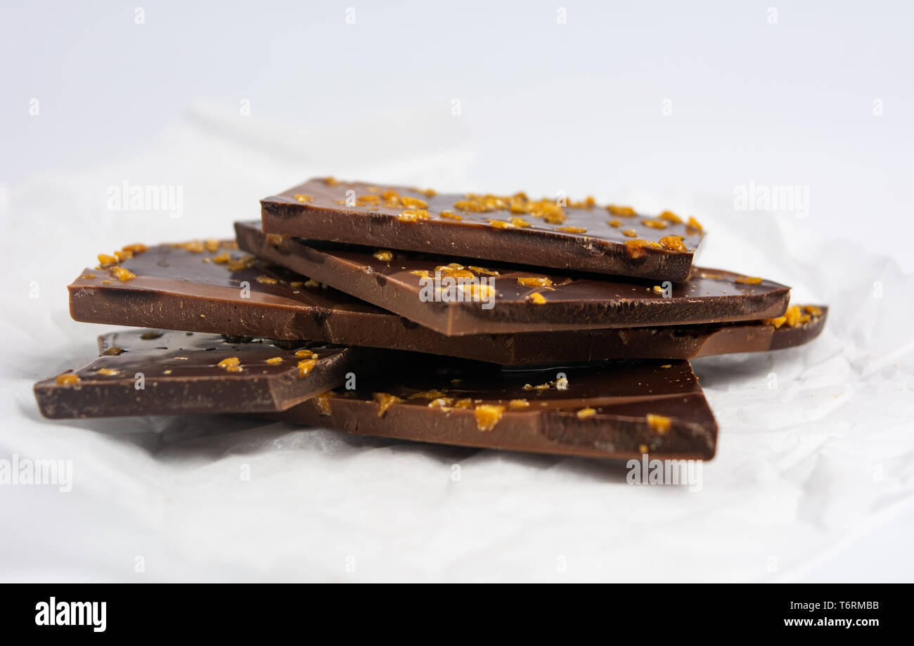 Stück Schokolade mit Mandeln auf weißem Hintergrund Stockfoto