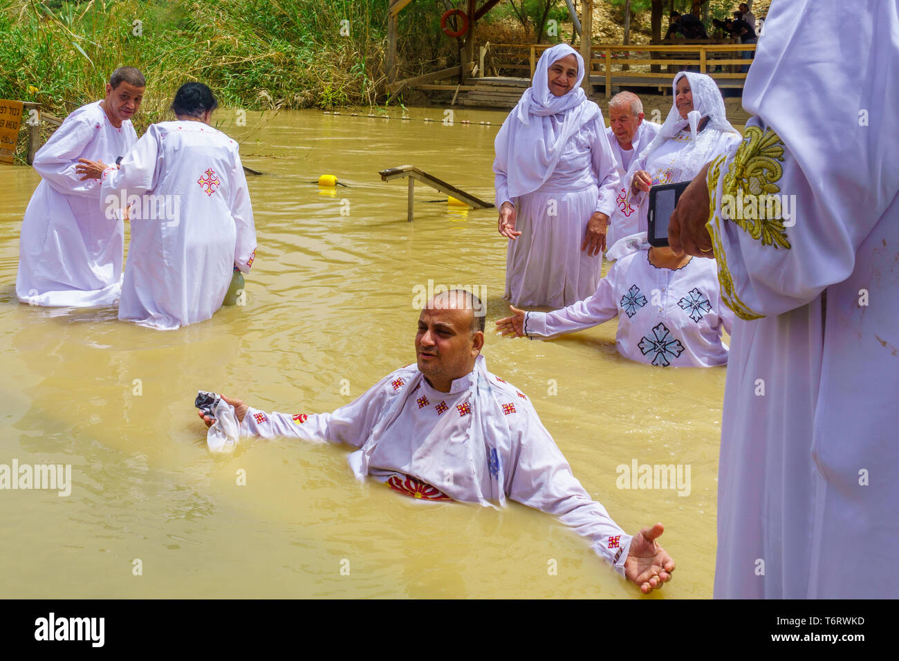 Qasr el Yahud, West Bank - April 24, 2019: Pilger Taufen in Qasr el Yahud (Schloss der Juden), im Fluss Jordan. Es ist der traditionelle Ort der Stockfoto