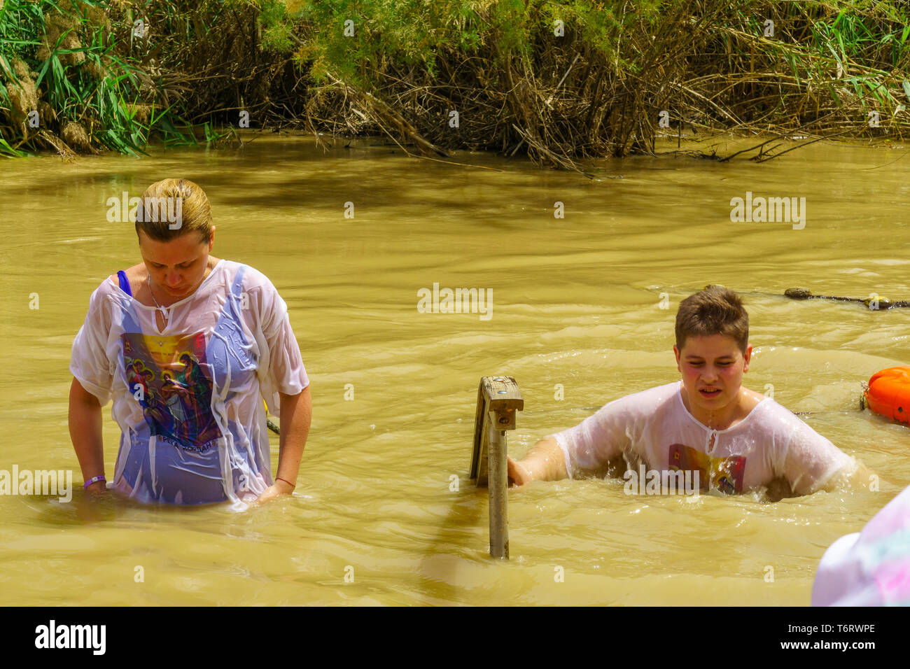 Qasr el Yahud, West Bank - April 24, 2019: Pilger Taufen in Qasr el Yahud (Schloss der Juden), im Fluss Jordan. Es ist der traditionelle Ort der Stockfoto
