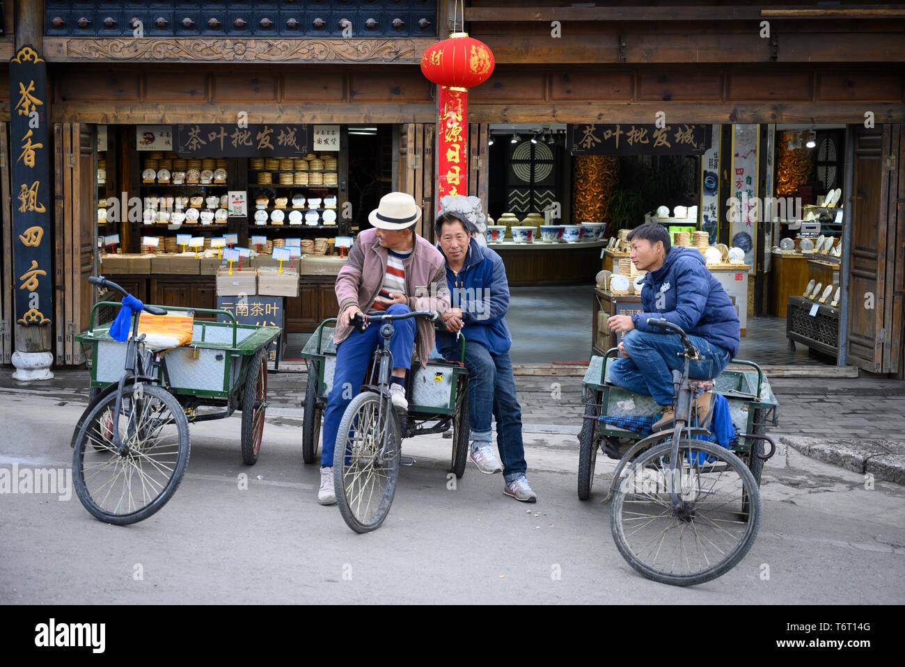 Tagelöhner für einen Job in der historischen Altstadt von Lijiang, China warten Stockfoto